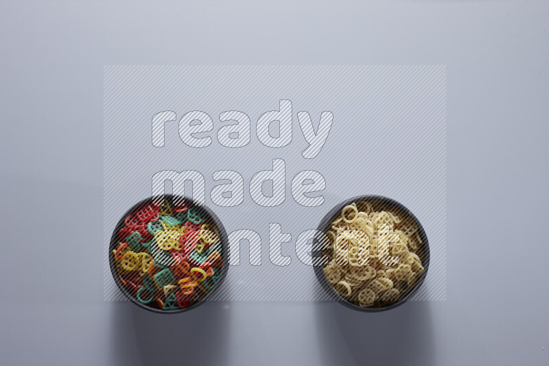 Legumes in pottery bowls on light grey background