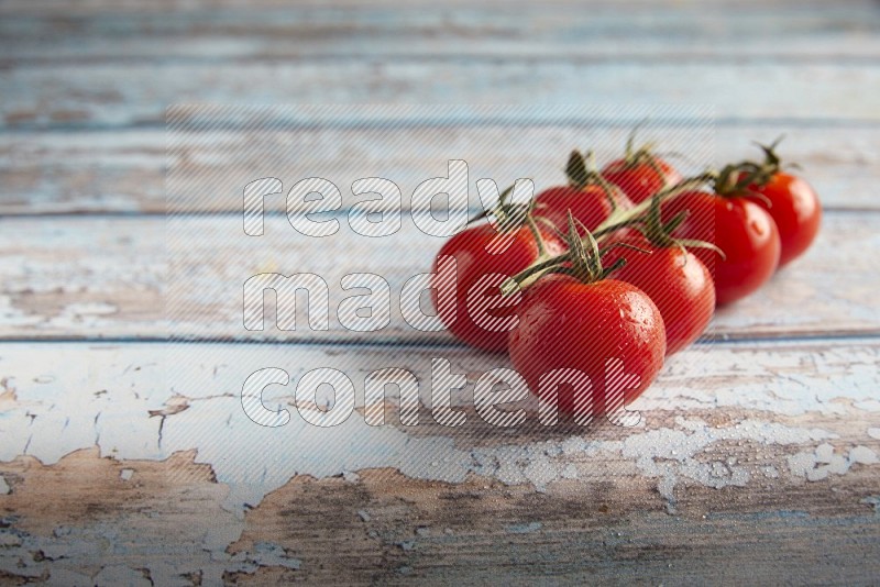 Red cherry tomato vein on a textured blue wooden background 45 degree