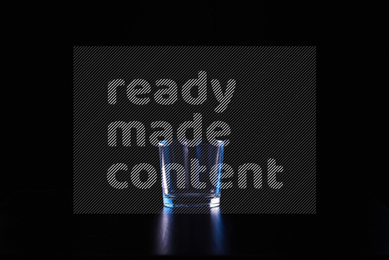 Glassware with rim light in blue and white against black background