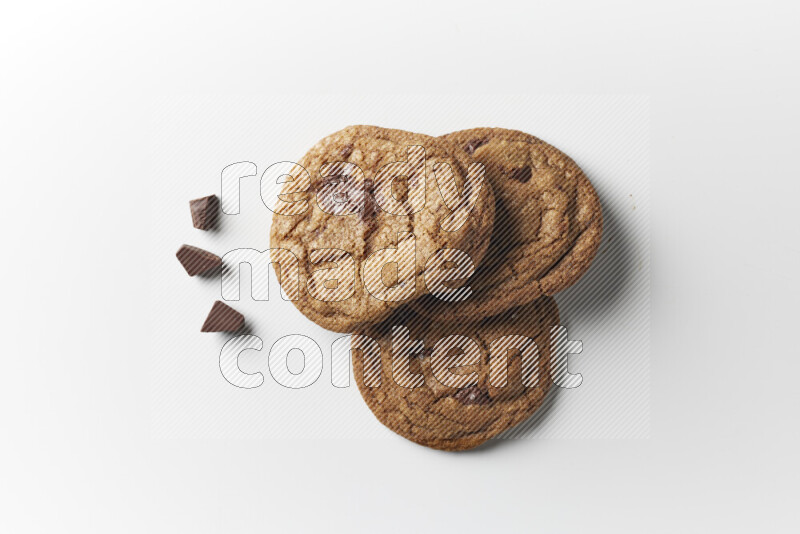 Chocolate chips cookies with chocolate beside it on a white background