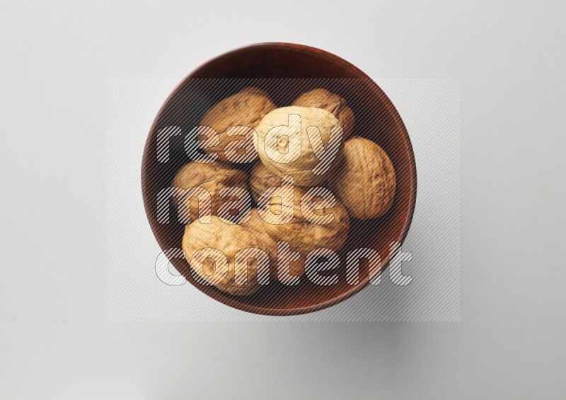Top-view shot of walnut in a container on white background