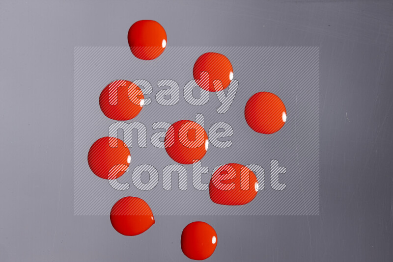 Close-ups of abstract red paint droplets on grey background
