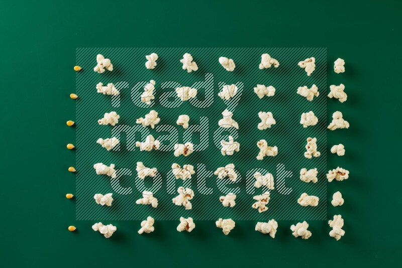 Popcorn flakes and seeds on a green background in a top view shot