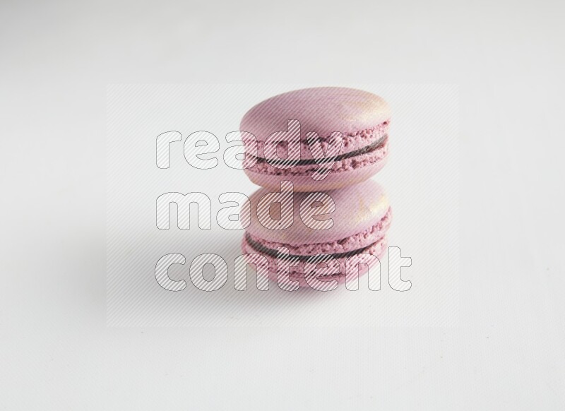 45º Shot of two Purple Strawberry macarons on white background