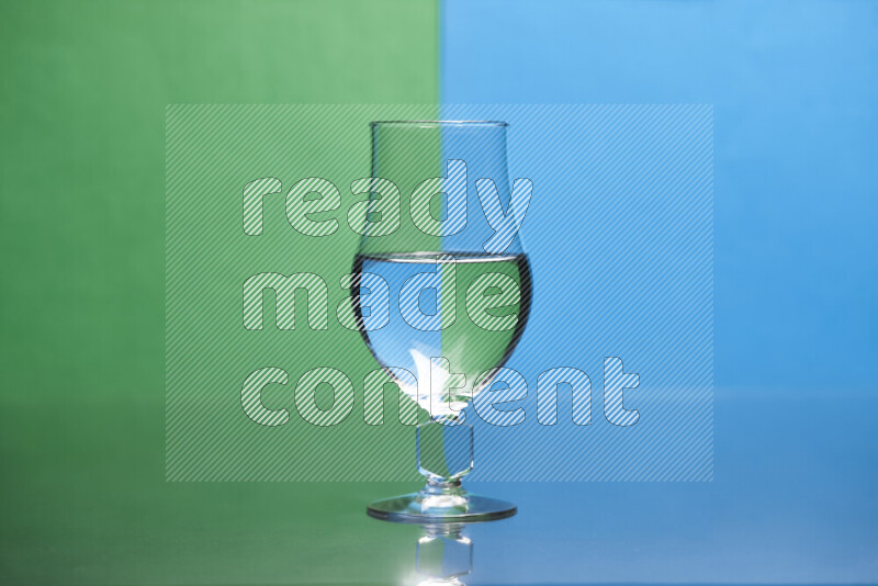 The image features a clear glassware filled with water, set against green and blue background