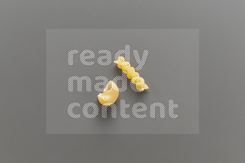 Pipe pasta with other types of pasta on grey background