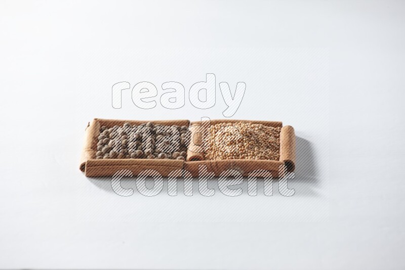 2 squares of cinnamon sticks full of mustard seeds and allspice on white flooring