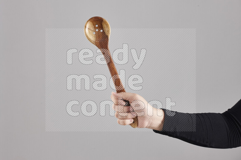 امرأة ترتدي عباءة سوداء تحمل أدوات خشبية مختلفة في أوضاع متعددة