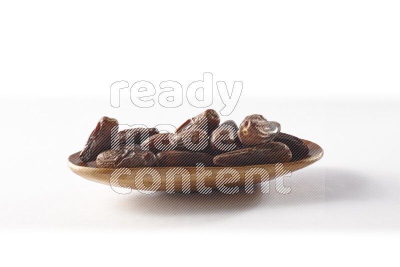 Dates in a wooden plate on white background