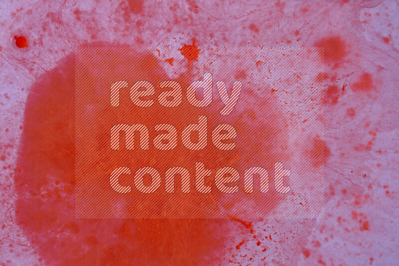 The image captures a dramatic splatter of red paint over a white backdrop