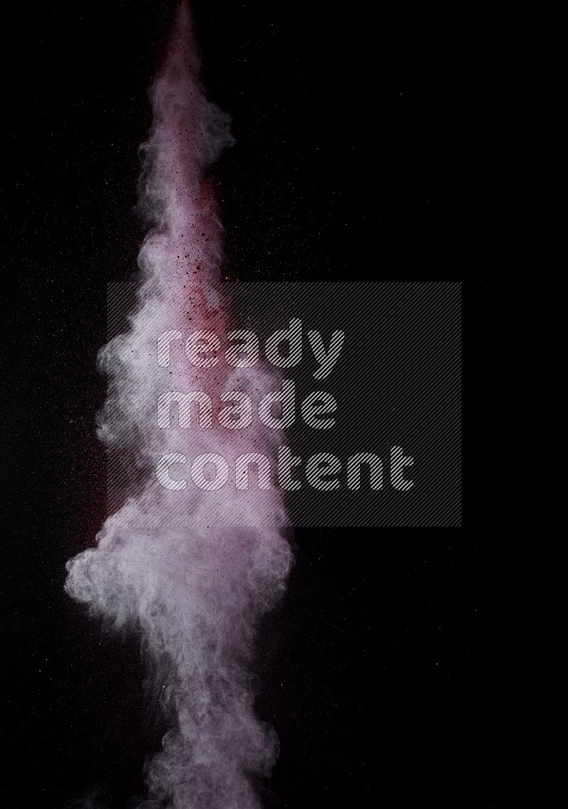 A side view of red powder explosion on black background