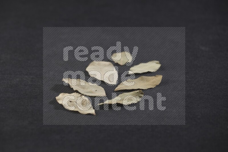 Dried bay leaves on black flooring
