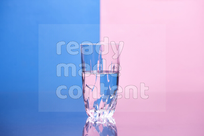 The image features a clear glassware filled with water, set against blue and rose background