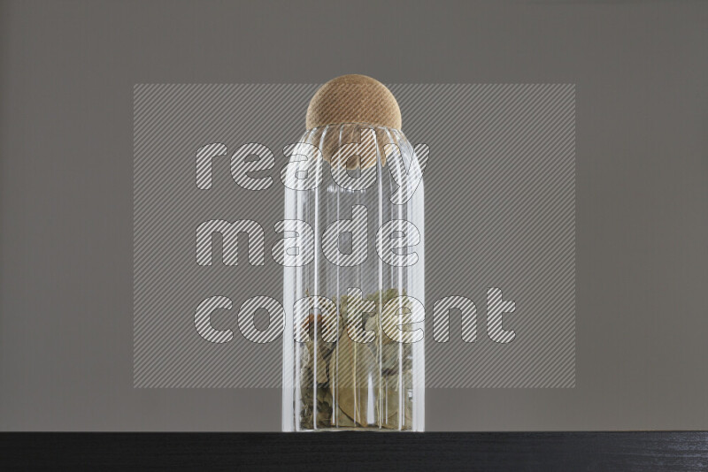 Bay laurel leaves in a glass jar on black background