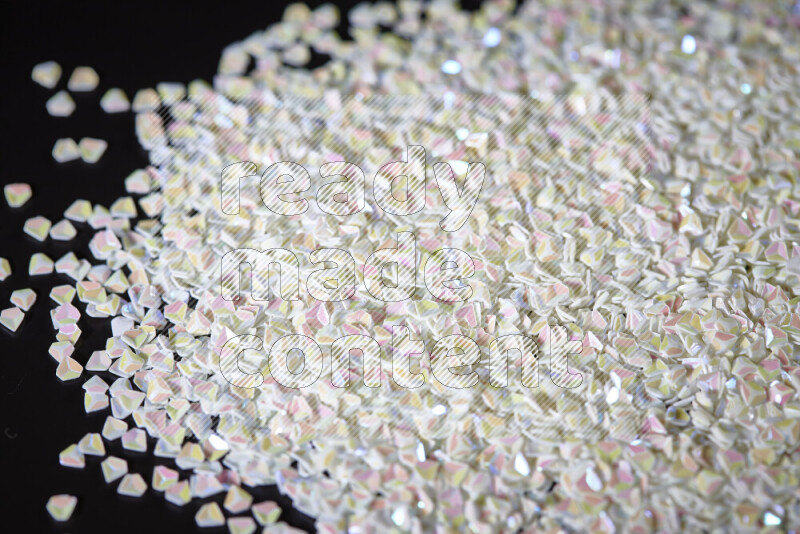 Colorful plastic shards for decoration scattered on a black background