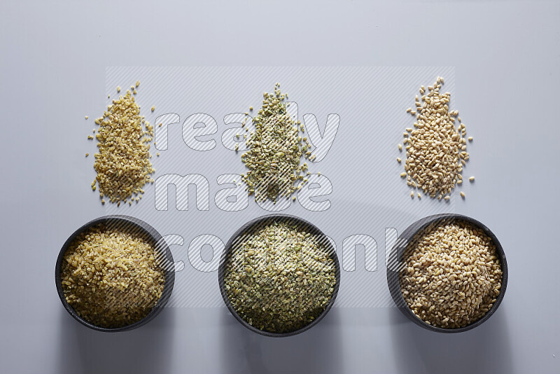 Legumes in pottery bowls on light grey background