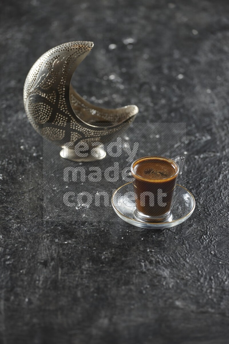 A silver lantern with different drinks, dates, nuts, prayer beads and quran on textured black background