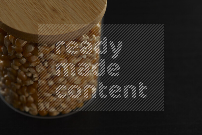 Pop corn in a glass jar on black background