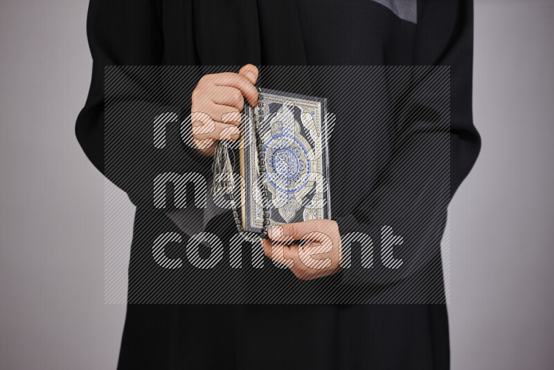 A woman hands holding moshaf in different positions