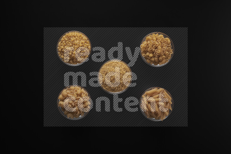 أنواع مختلفة من المعكرونة في أوعية زجاجية علي خلفية سوداء