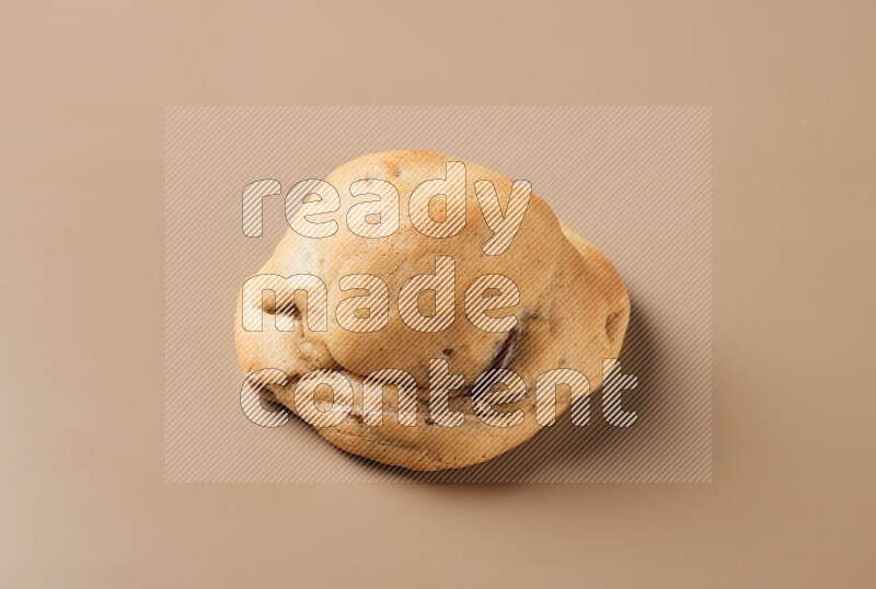 a whole chocolate chip cookie on a brown background