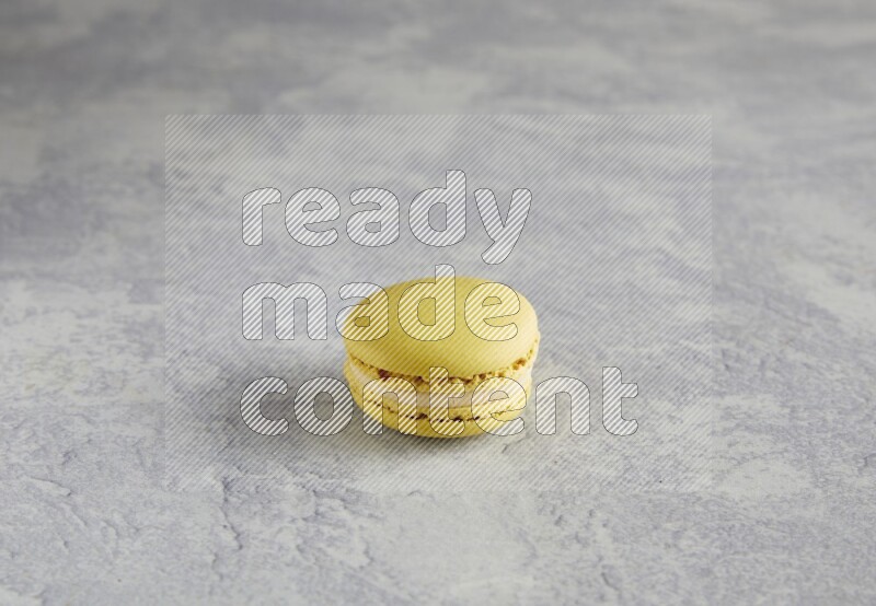 45º Shot of Yellow Lime macaron on white marble