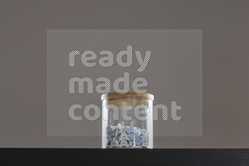 أزرار متنوعة في وعاء زجاجي علي خلفية سوداء