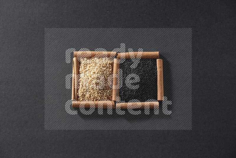 2 squares of cinnamon sticks full of sesame and black seeds on black flooring