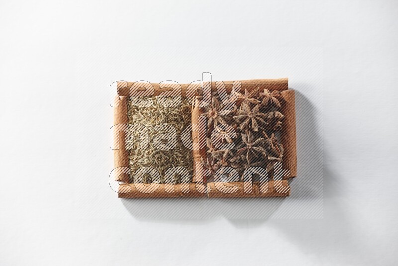 2 squares of cinnamon sticks full of star anise and cumin on white flooring
