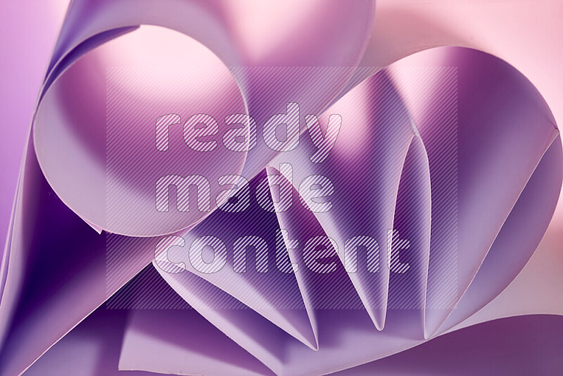 An artistic display of paper folds creating a harmonious blend of geometric shapes, highlighted by soft lighting in purple tones