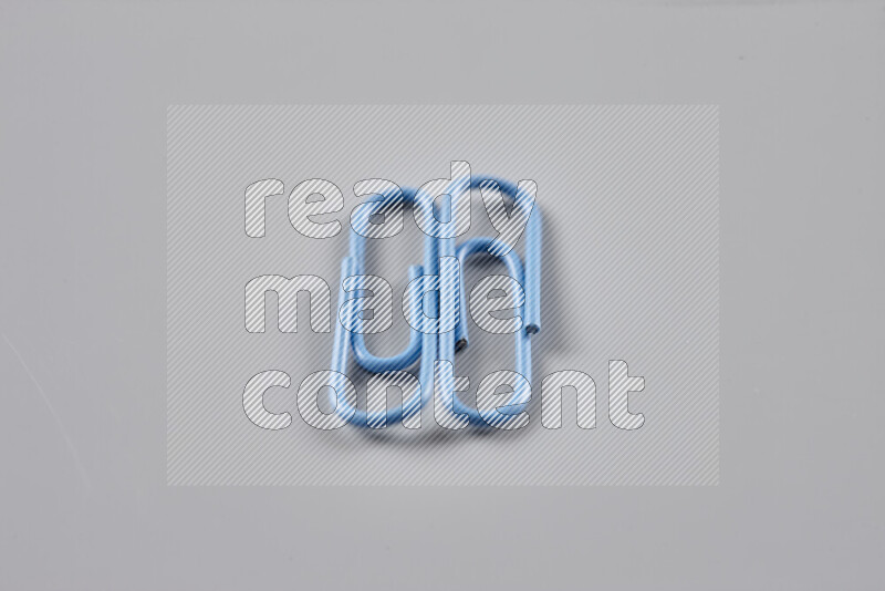 Blue paper clips isolated on a grey background