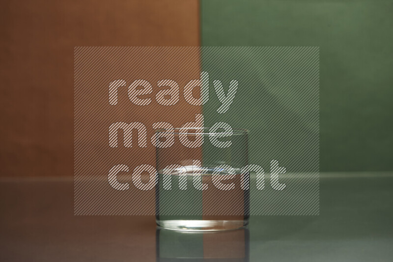 The image features a clear glassware filled with water, set against brown and dark green background