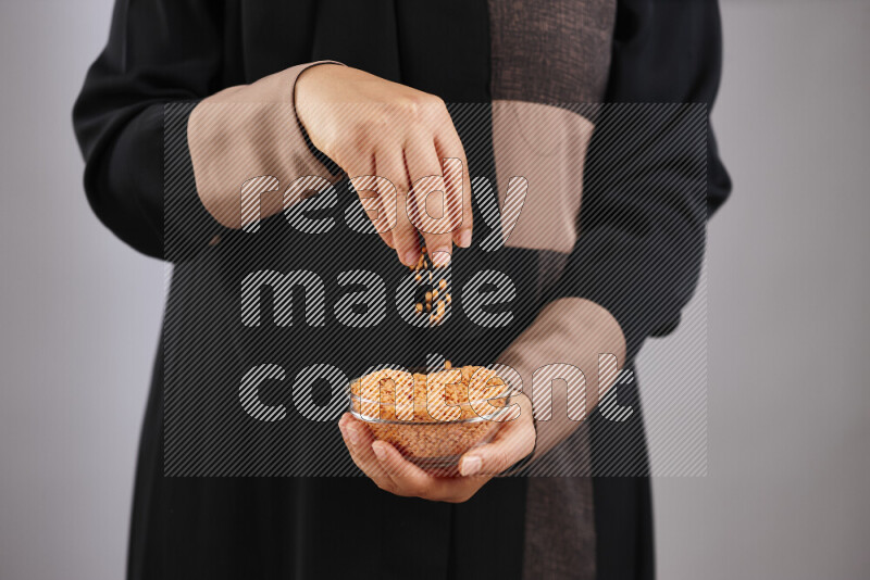 Woman in abaya holding different kinds of legumes in different positions