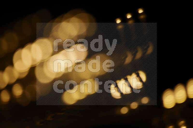 Light bulbs glowing against backdrop of golden bokeh