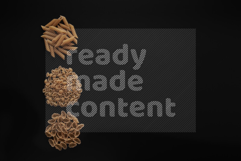 Different pasta types in 3 bunches on black background