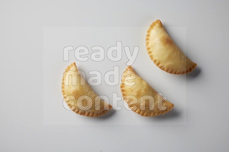 Three fried sambosa from a top angle on a white background