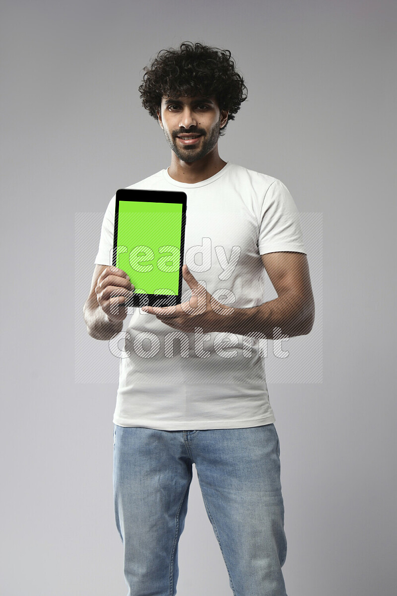 A man wearing casual standing and showing a tablet screen on white background