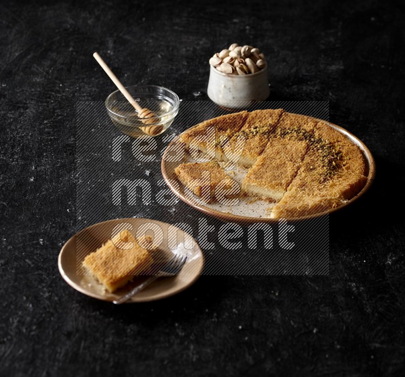 Konafa with nuts and honey in a dark setup