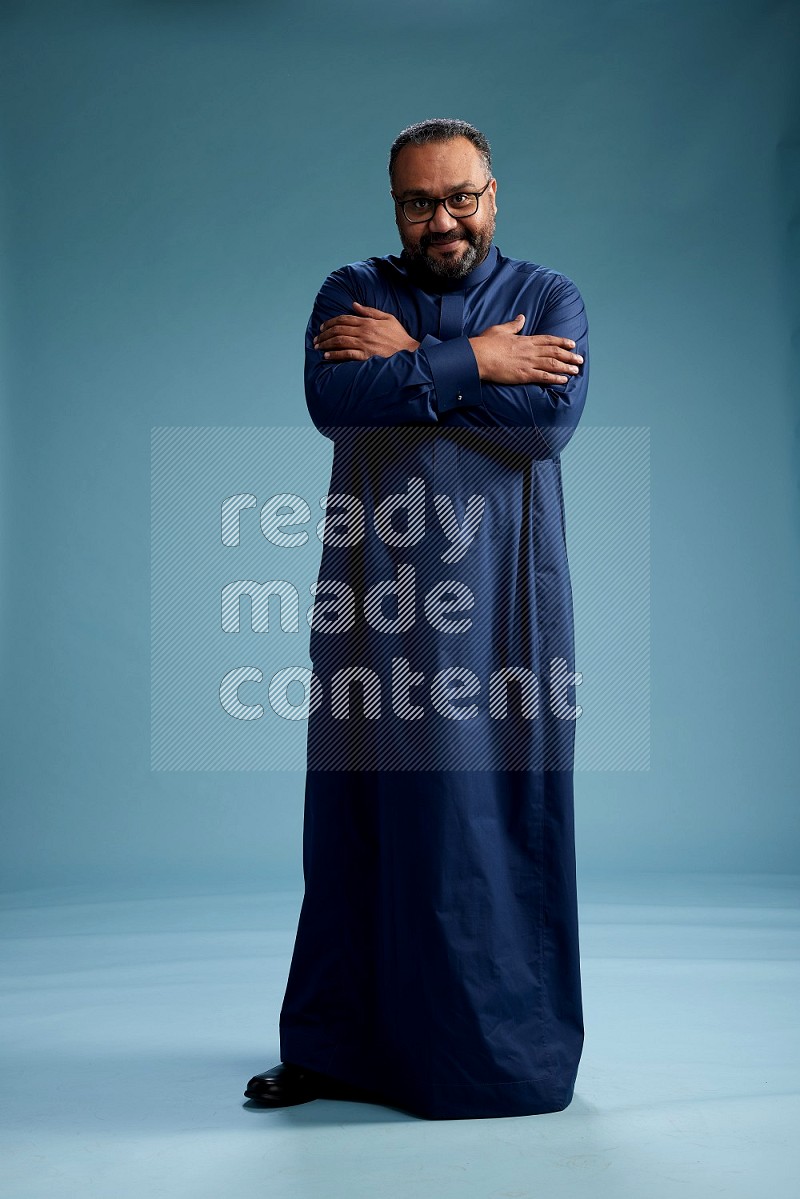 Saudi Man without shimag Standing Interacting with the camera on blue background