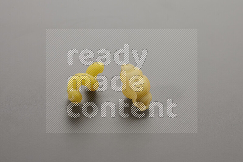 Twist pasta with other types of pasta on grey background