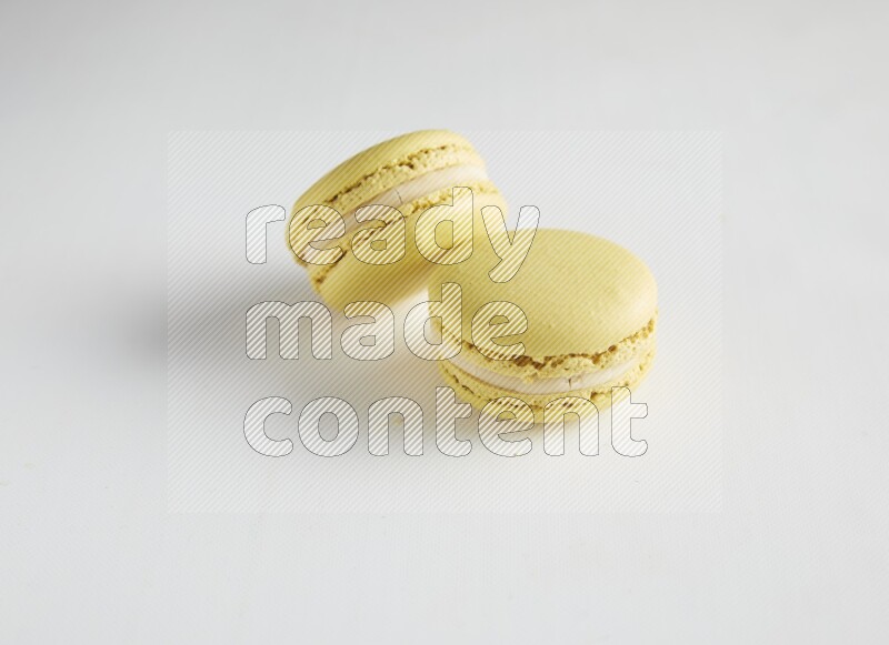 45º Shot of two Yellow Lime macarons on white background