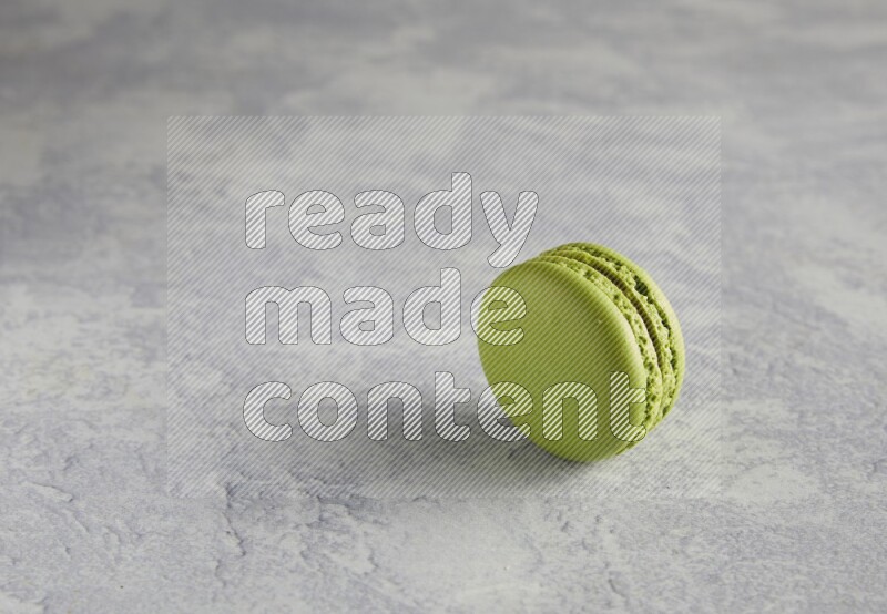 45º Shot of Yellow Lime macaron on white  marble background