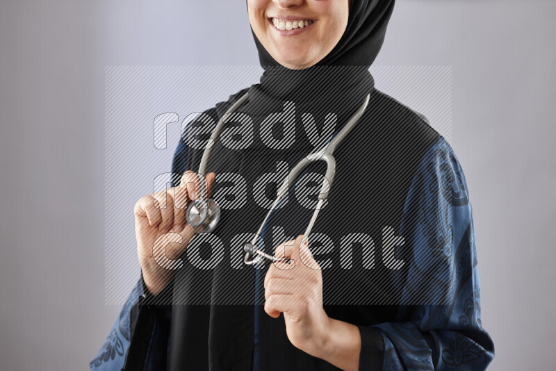 Female doctor wearing an abaya and medical attire in different positions