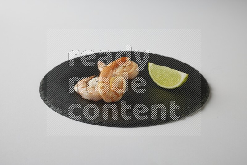 three grilled shrimp  on a black slate direct  on a white back ground