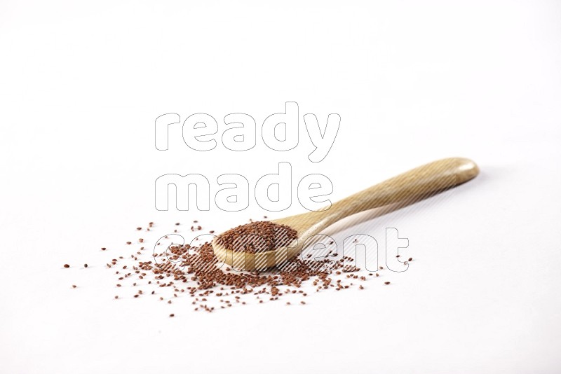 A wooden spoon full of garden cress seeds on a white flooring