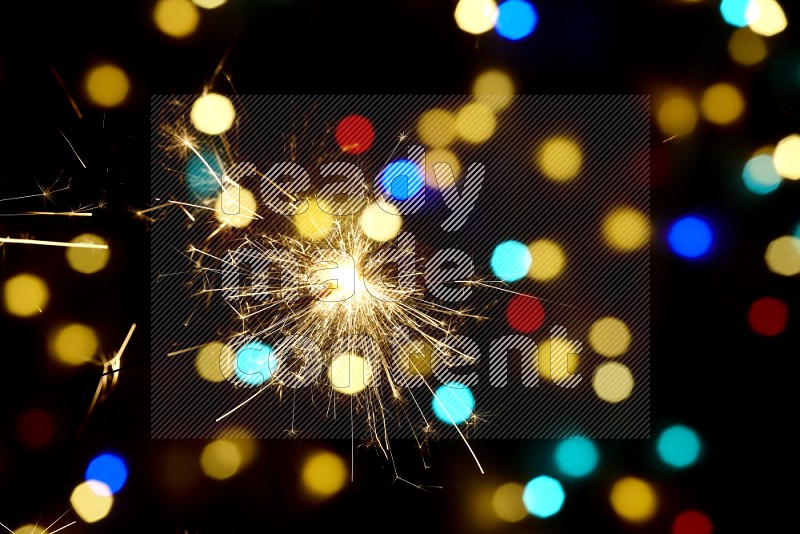 Sparkler candles with multicolored light bokeh background