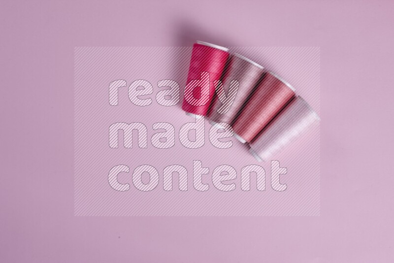 A pink collection of sewing and tailoring tools arranged on a pink background