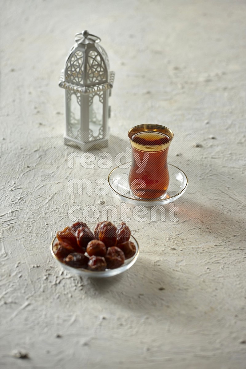 A white lantern with drinks, dates, nuts, prayer beads and quran on textured white background
