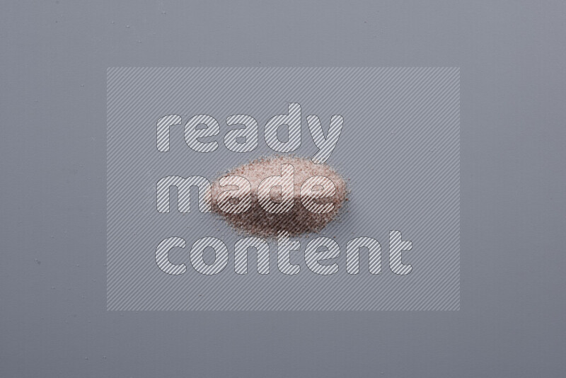 Bunches of table salt, coarse sea salt, fine himalayan salt and coarse himalayan salt on grey background