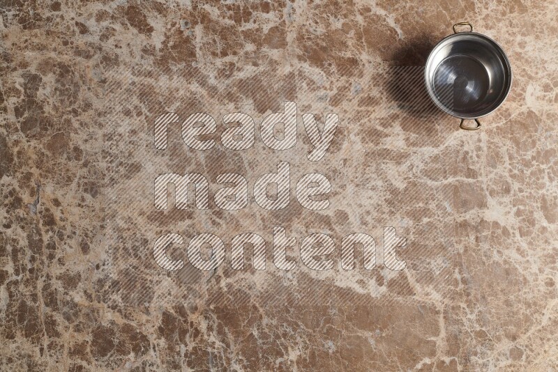 A small copper pot on beige marble background